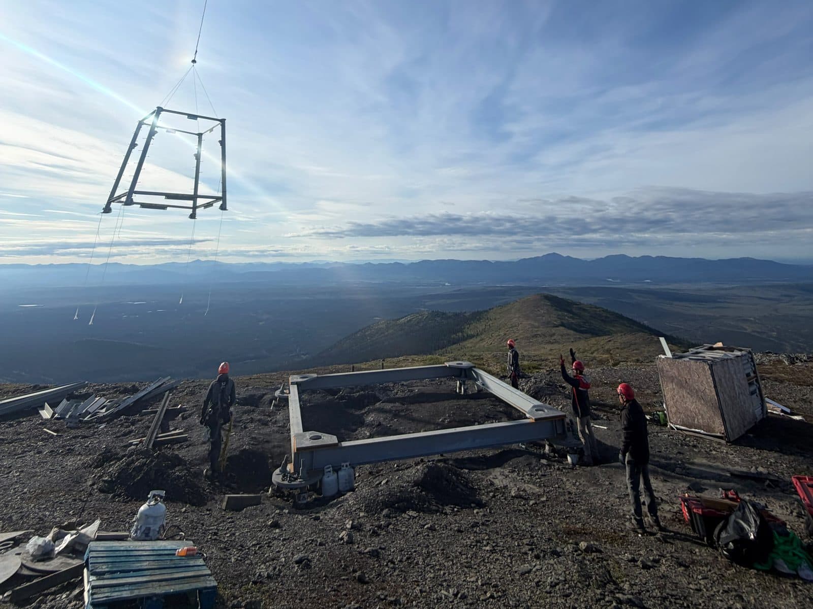 Ground crew signalling a helicopter lift on a ridge-top tower site